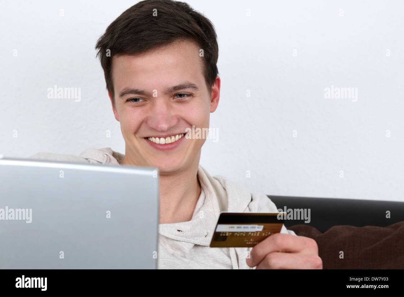 A young man is using his laptop computer for internet shopping Stock Photo