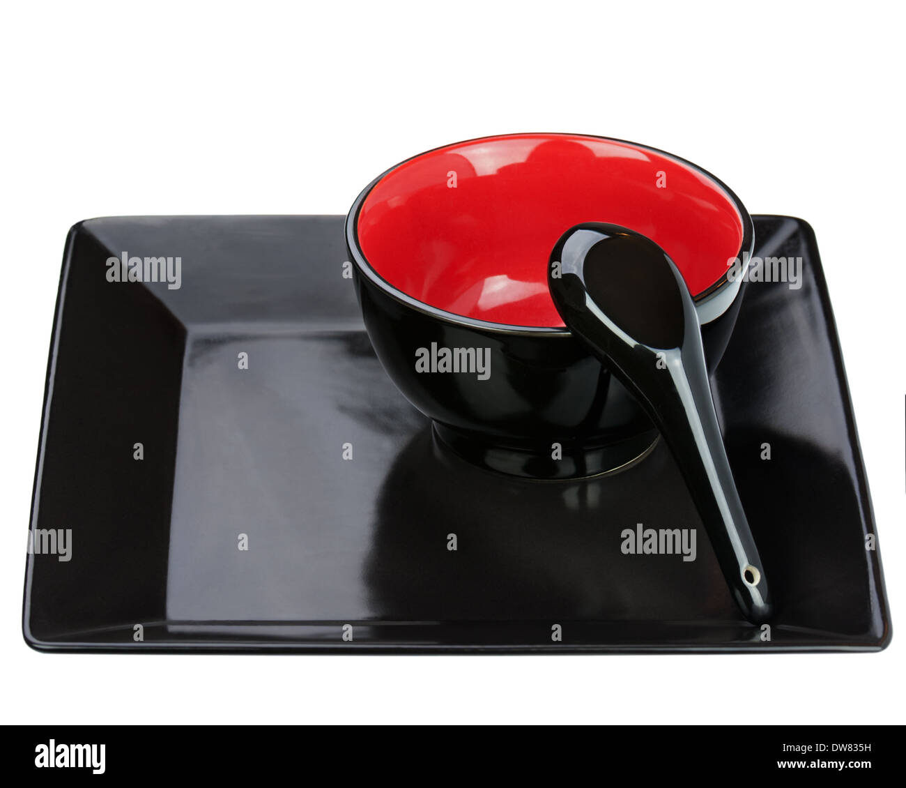 Black ceramic bowl and spoon on tray isolated on white background. Closeup. Stock Photo