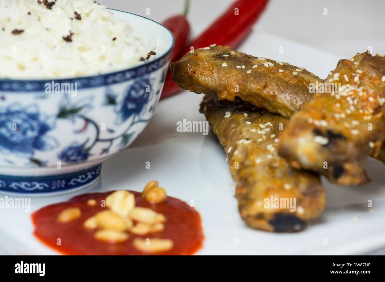 Hot and spicy spareribs served with rice and chili and peanuts Stock Photo