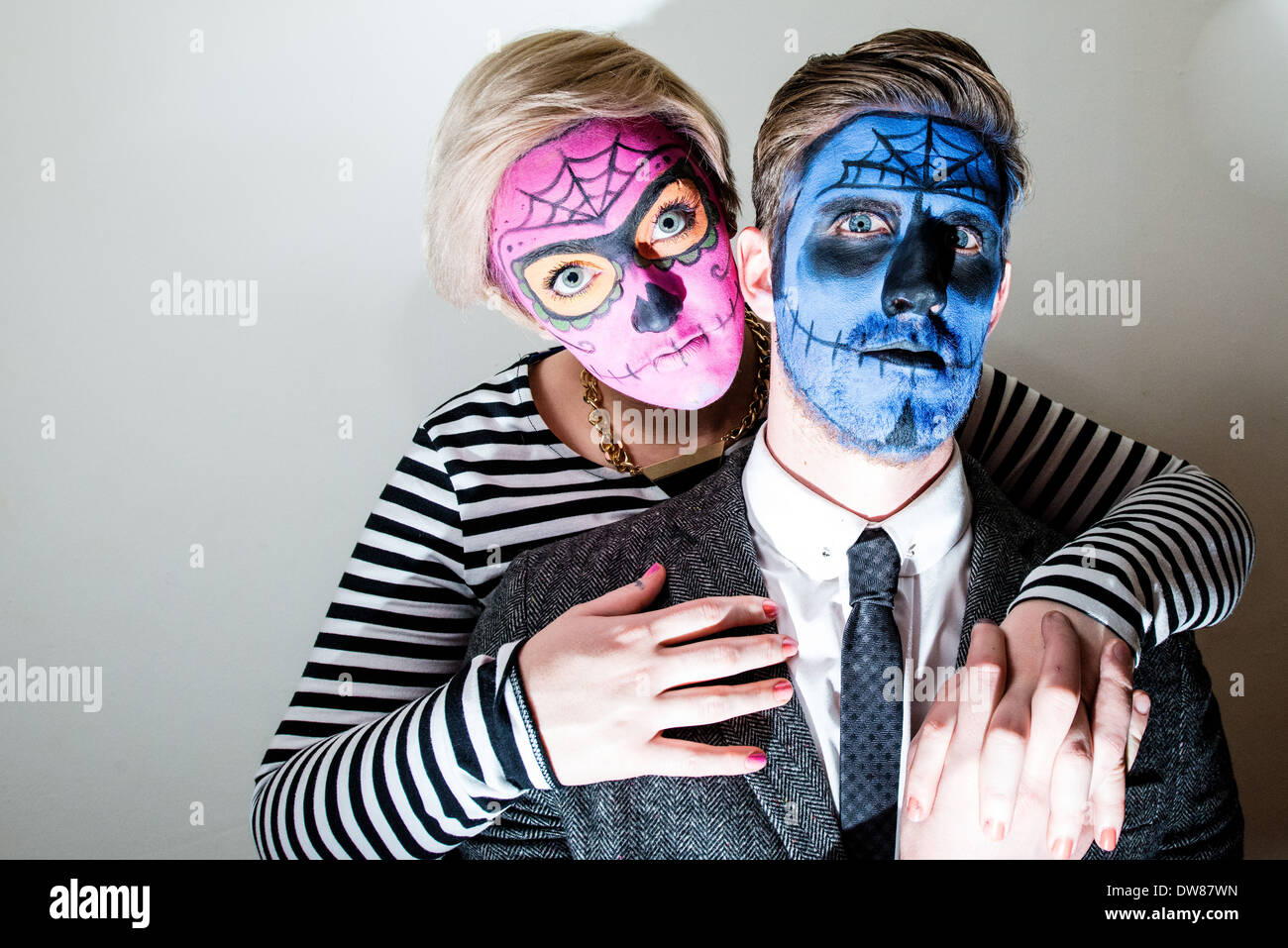 Attractive young couple with horror style face paint on white. Stock Photo