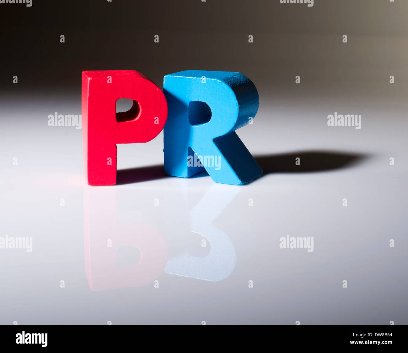 Multicolored text PR made of wood. White background Stock Photo
