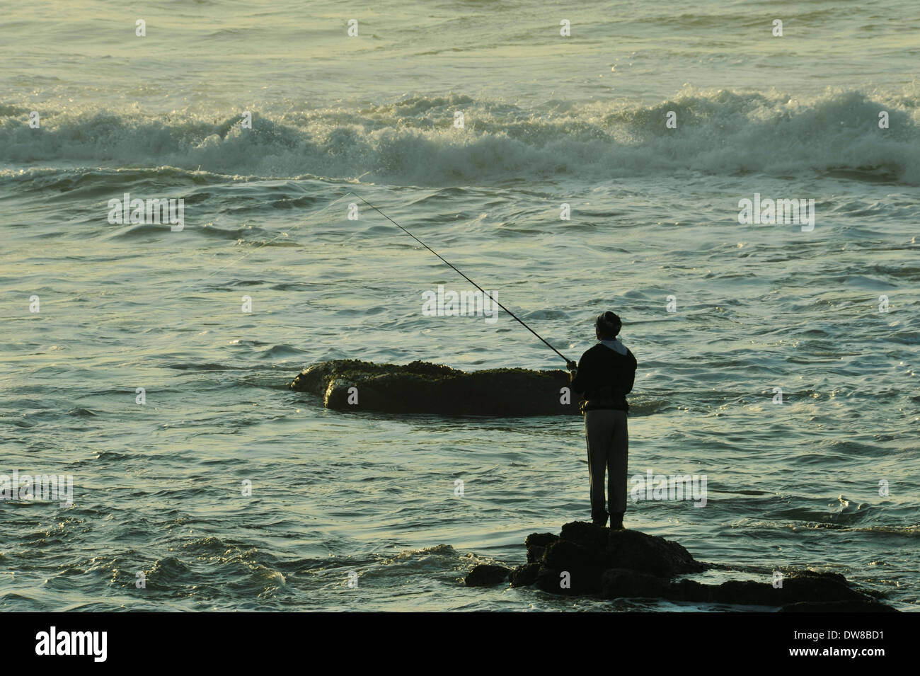 Durban, KwaZulu-Natal, South Africa, silhouette, adult, man fishing at dawn, standing on rock, Umhlanga Rocks beach, people, Stock Photo