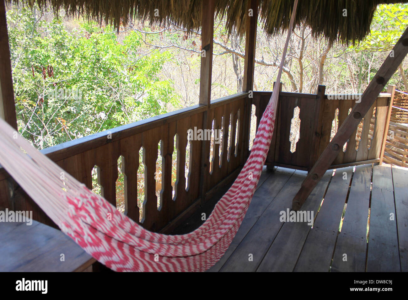 Hammock strung up on balcony of ecological lodge El Copal, Mermejita Beach, Maxunte, S. Oaxaca, Mexico Stock Photo
