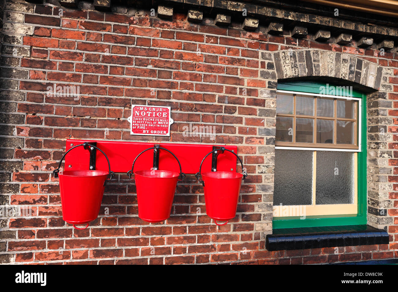 Red fire buckets on the platform at Sheringham Station in North Norfolk. Stock Photo