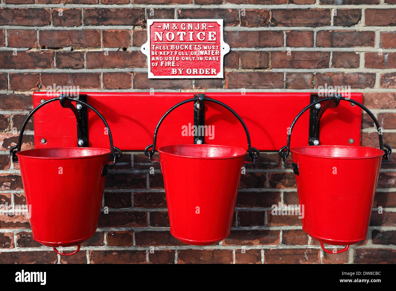 Red fire buckets on the platform at Sheringham Station in North Norfolk. Stock Photo