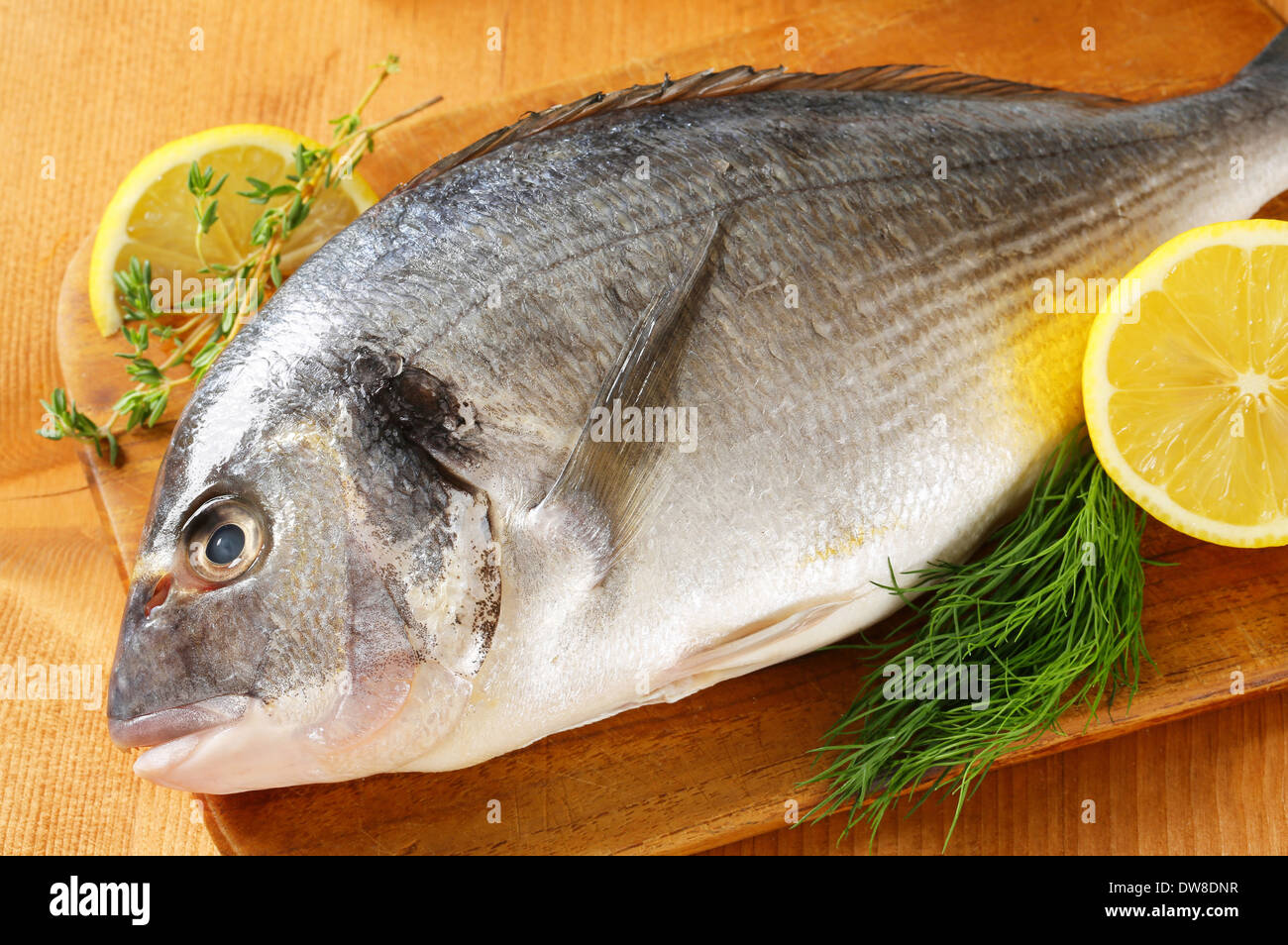 Fresh sea bream and lemon on cutting board Stock Photo