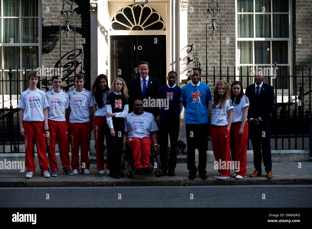 City of London Academy pupils and young British Badminton athletes pose with Prime Minister David Cameron outside Downing Street on March 28, 2012 in London, England. The young athletes will compete in the finals of the School Games later this year, which is a mirror version of the Olympics for young people. (Photo by Tal Cohen) Stock Photo
