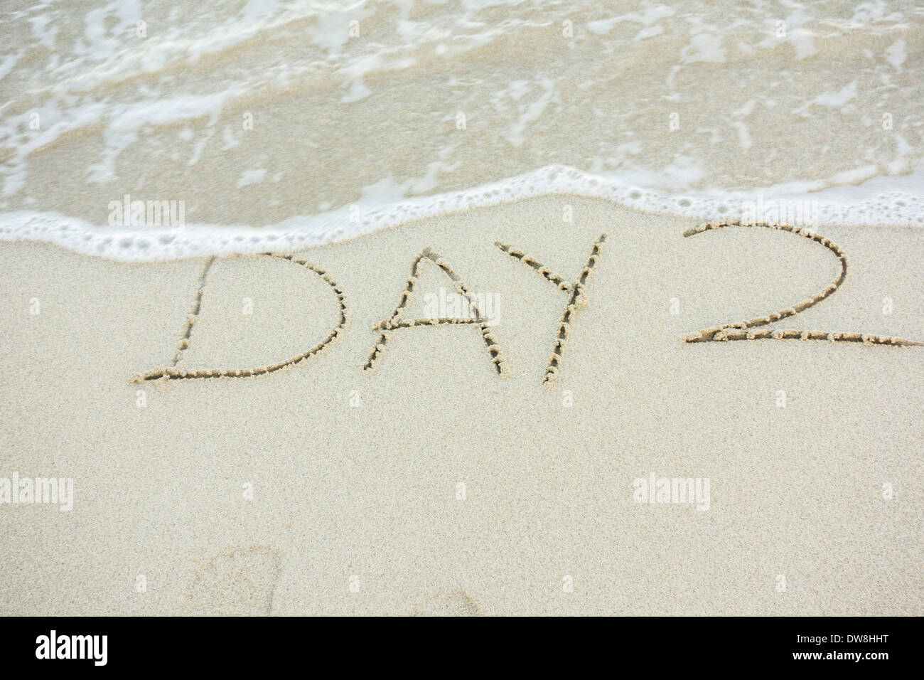 A message written in the beach sand on the west end of St. Croix, U. S. Virgin Islands, saying 'Day 2'. Stock Photo