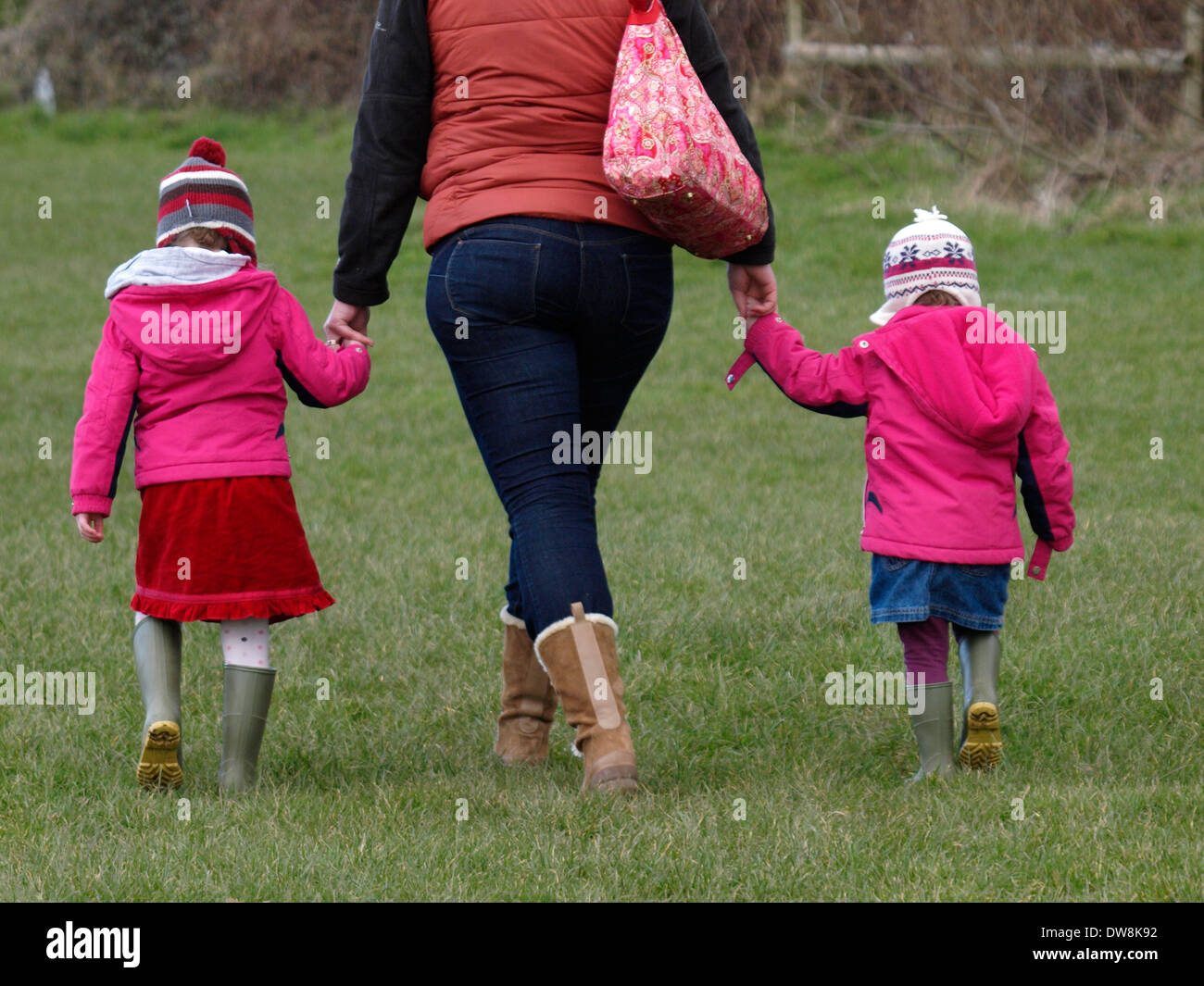 Mum walking with two young girls, Bude, Cornwall, UK Stock Photo