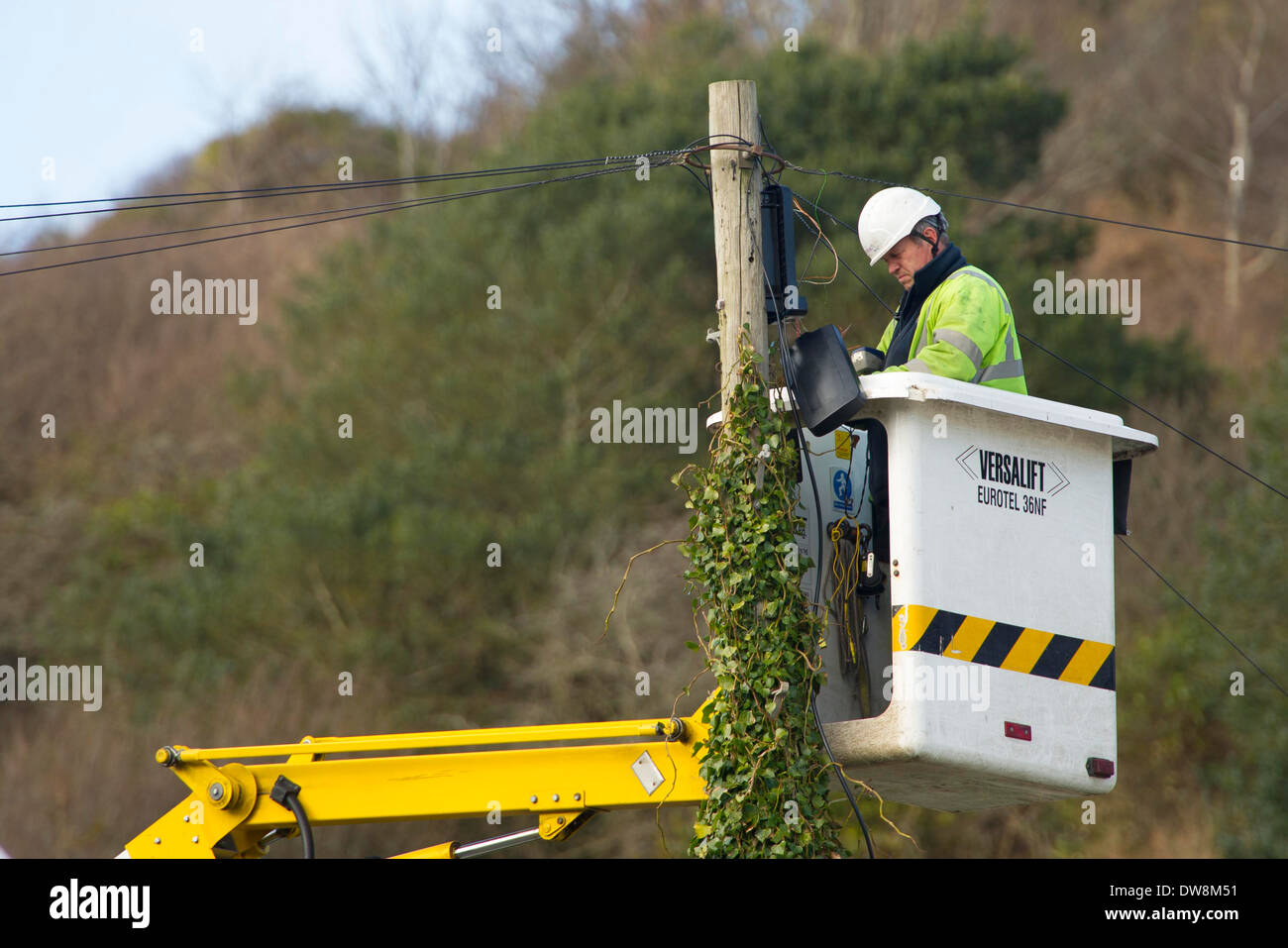 A BT telephone engineer works on a telephone pole. Stock Photo