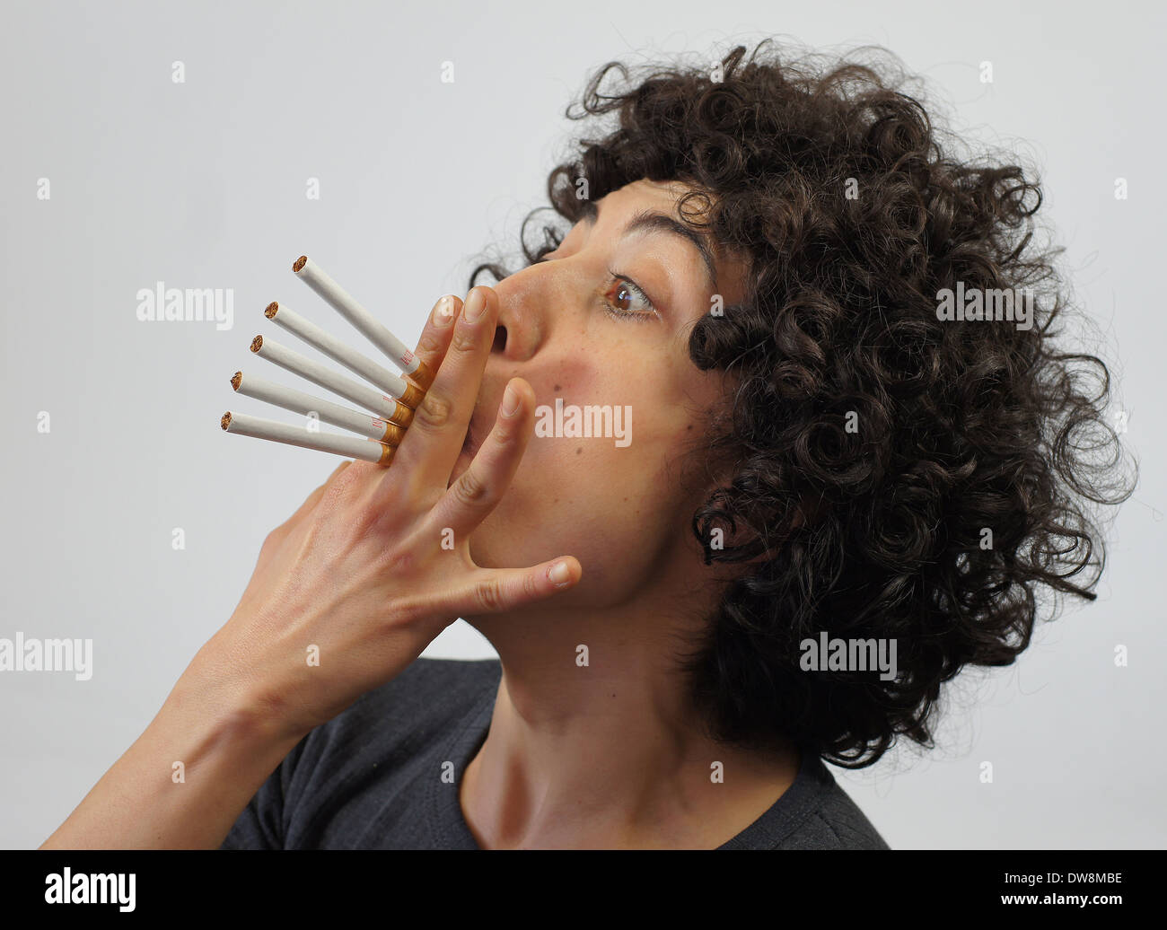 Woman smokes 5 cigarettes Stock Photo
