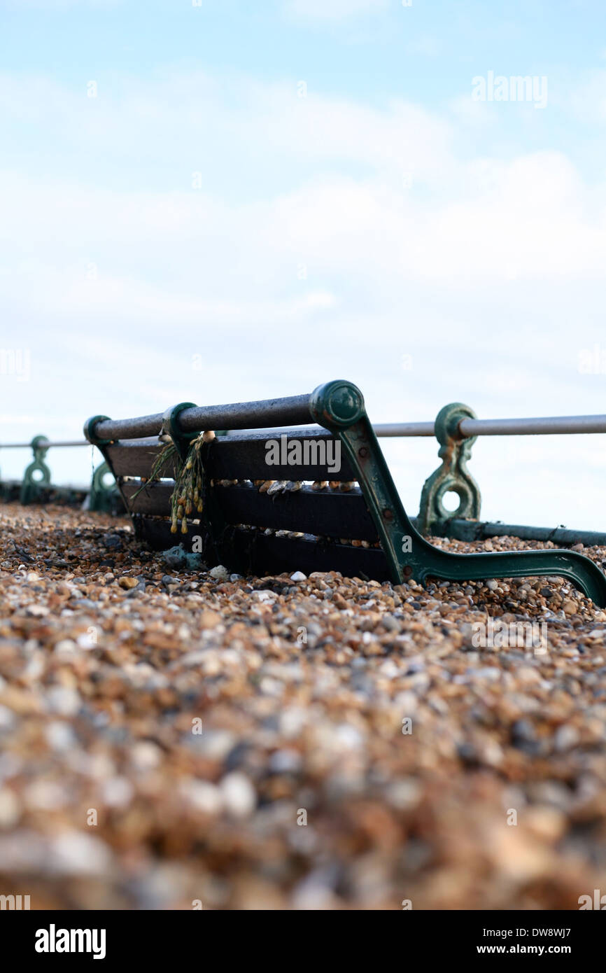 A bench on Brighton seafront in pebbles after storms of 2014 Stock Photo