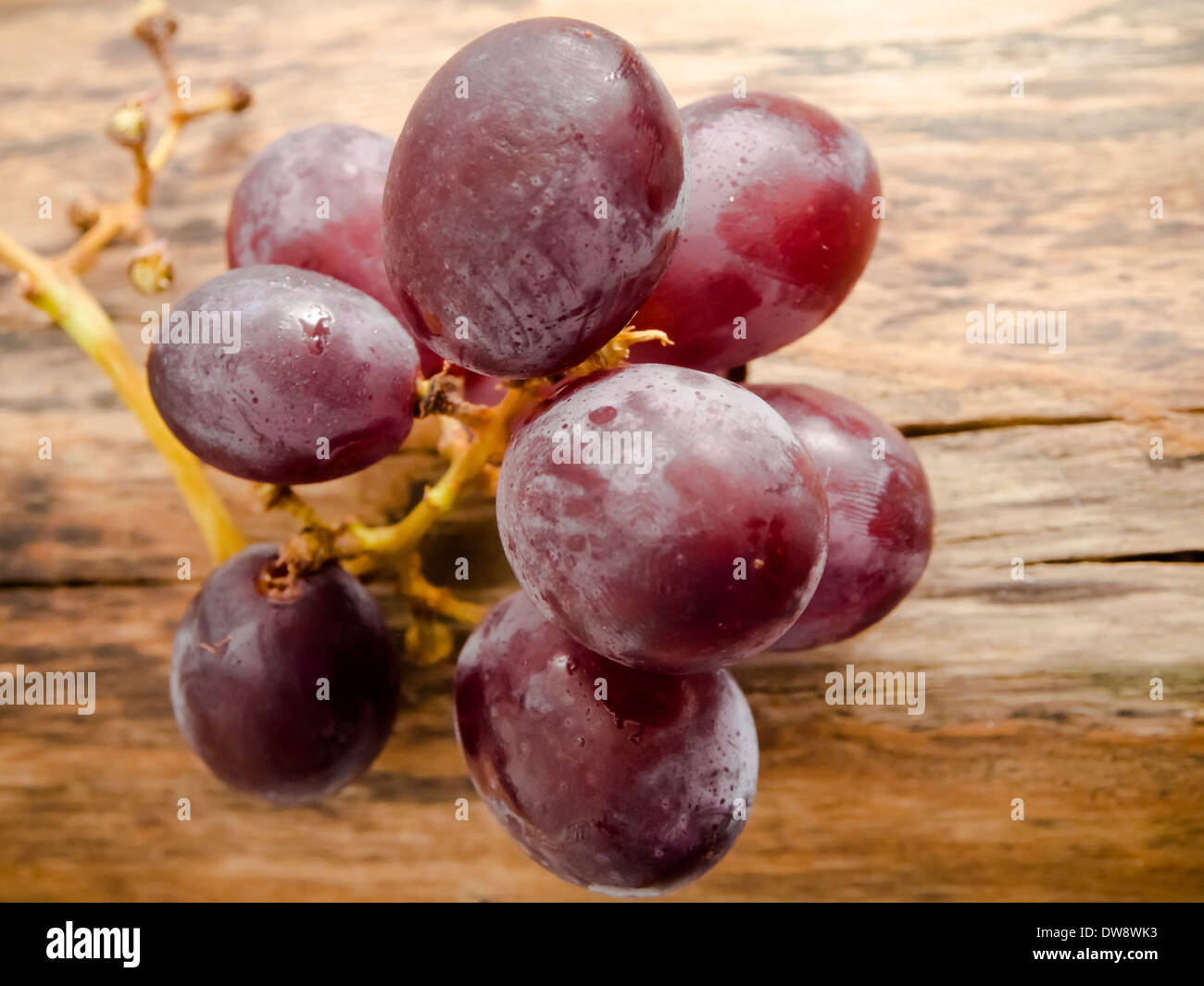 red grapes on a natural wooden background Stock Photo