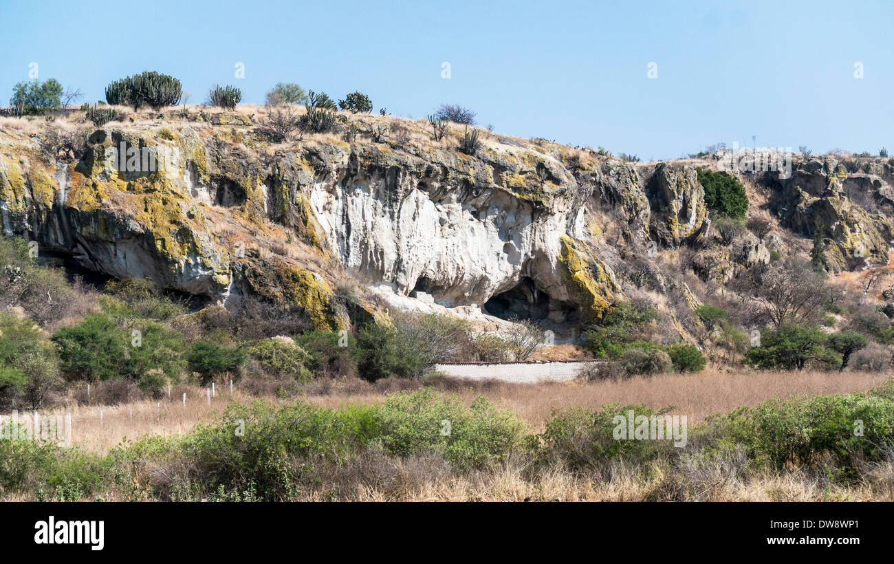 unusual lichen covered carpeted rock formations containing prehistoric caves at the entrance to Yagul archaeological zone Oaxaca Stock Photo