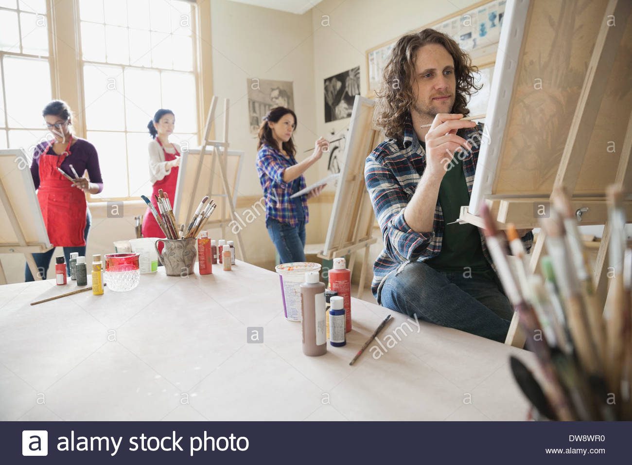 Adult students painting in art studio using easels Stock Photo