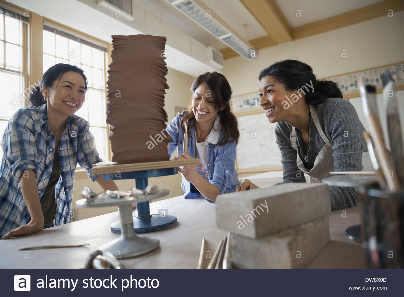 Female students working on clay sculpture Stock Photo