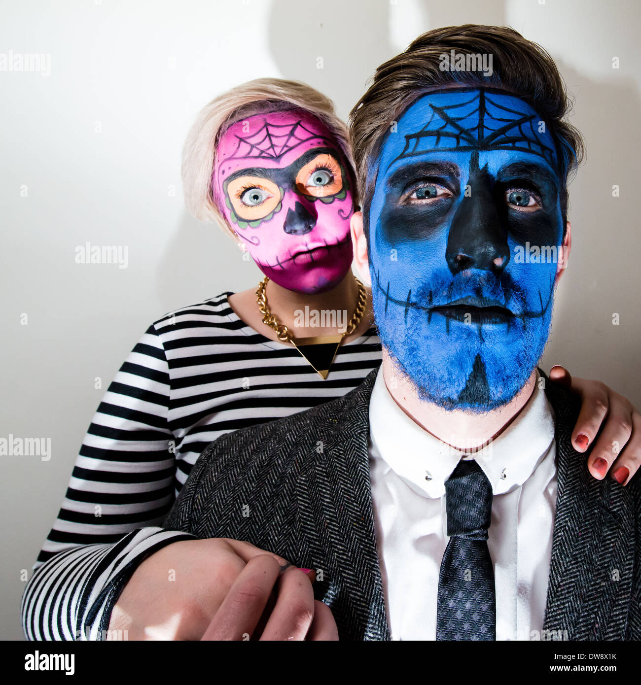 Attractive young couple with horror style face paint on white. Stock Photo