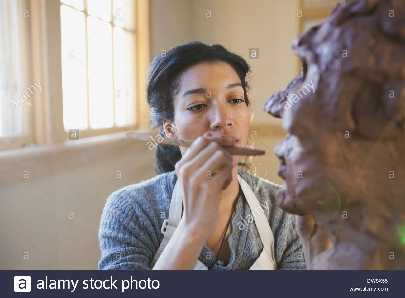 Artist working on clay sculpture in pottery studio Stock Photo Alamy