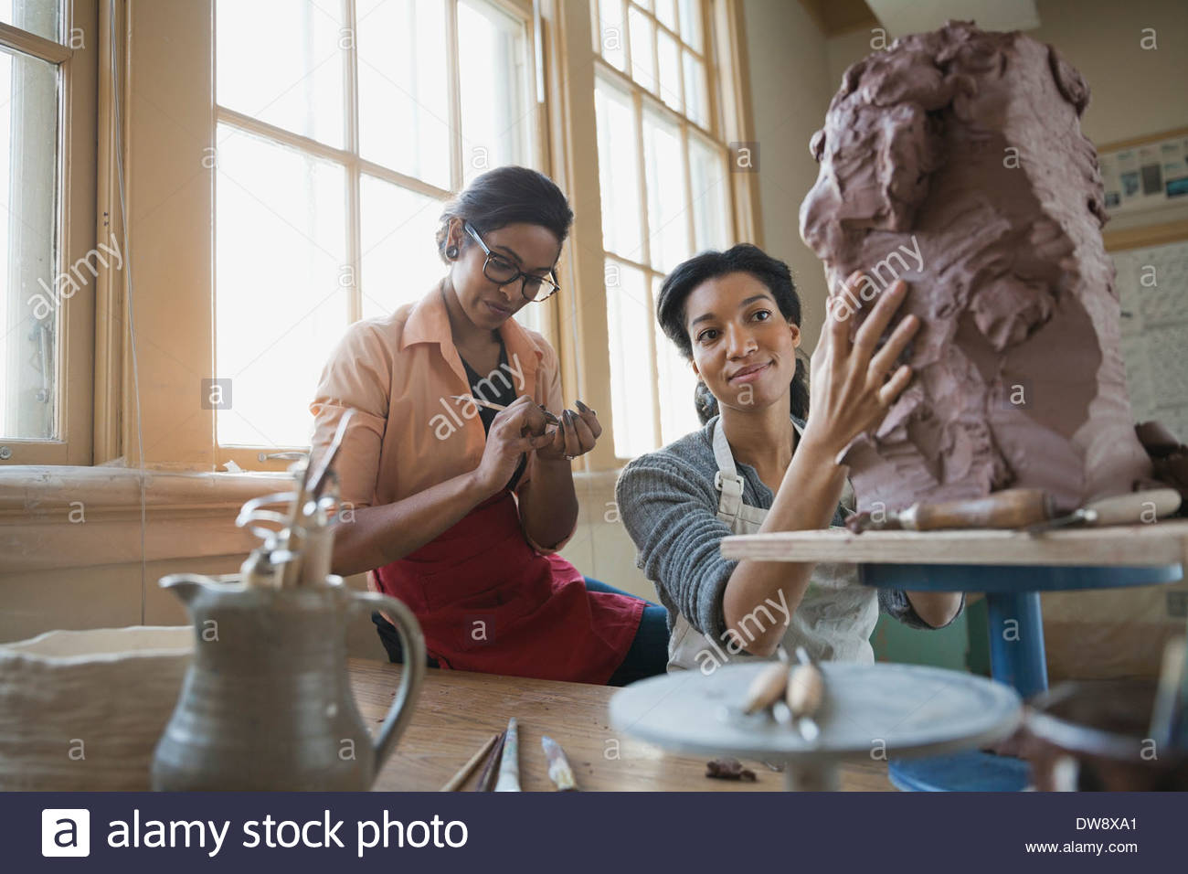 Female friends sculpting in art studio Stock Photo