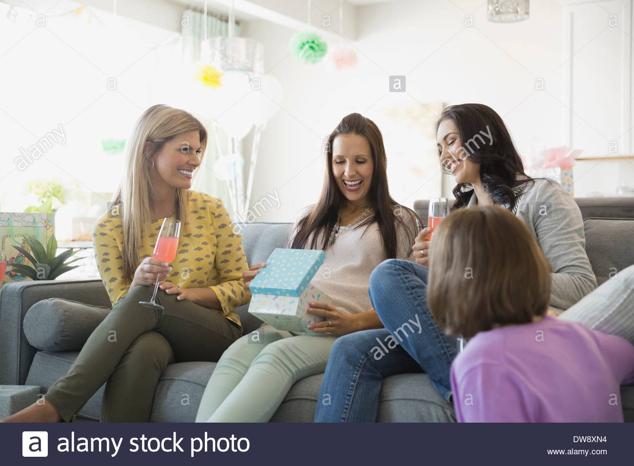 Cheerful women celebrating baby shower at home Stock Photo