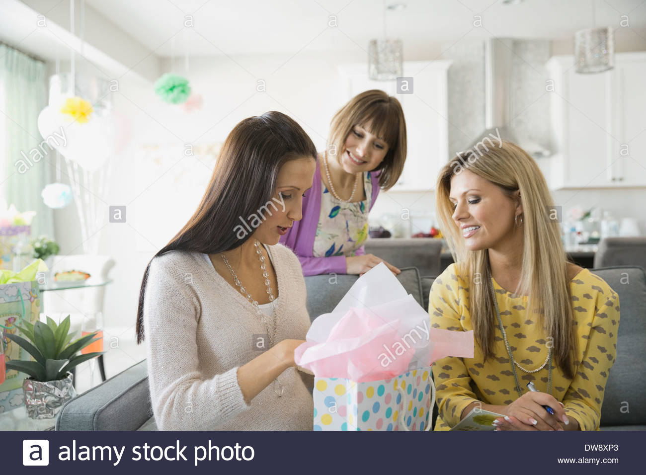 Woman opening gift at baby shower Stock Photo