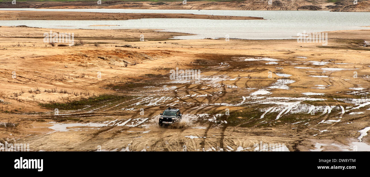 Folsom Lake, California, USA. 2nd March, 2014. A sport-utility splashes through a puddle on what is normally the bed of Folsom Lake in California on Sunday March 1. The lake, part of California's water suppl systemy, was at 33 percent capacity as of midnight March 2. The drought seems likely to affect farming this year in California, the biggest agricultural state in the U.S. Folsom Lake is north of Sacramento, the state capital. Credit:  E.J. Baumeister Jr./Alamy Live News Stock Photo