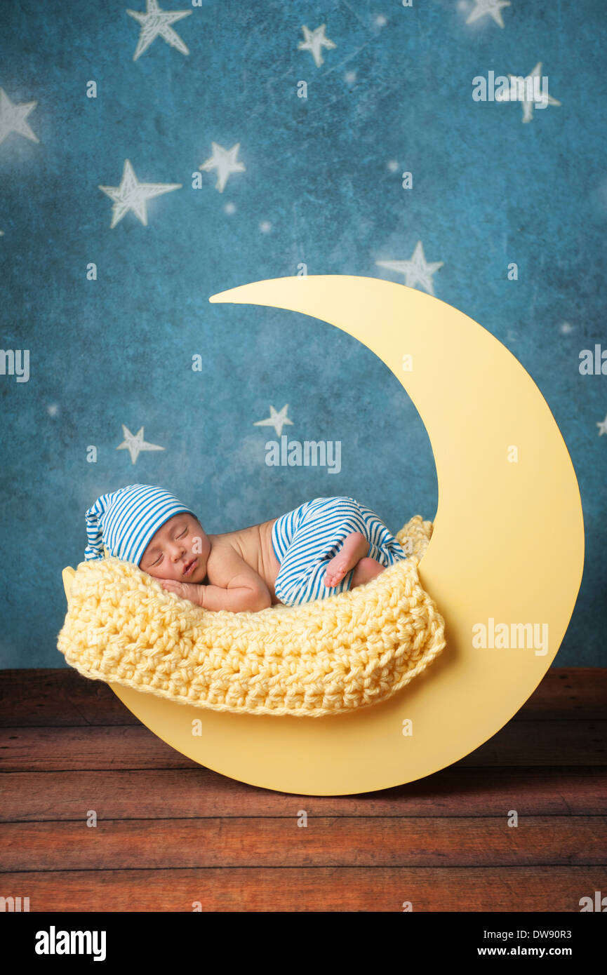 Newborn Baby Boy Sleeping on the Moon Stock Photo