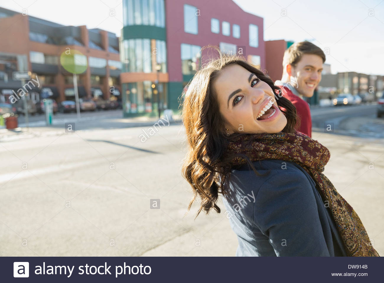 Cheerful woman looking back on city street Stock Photo