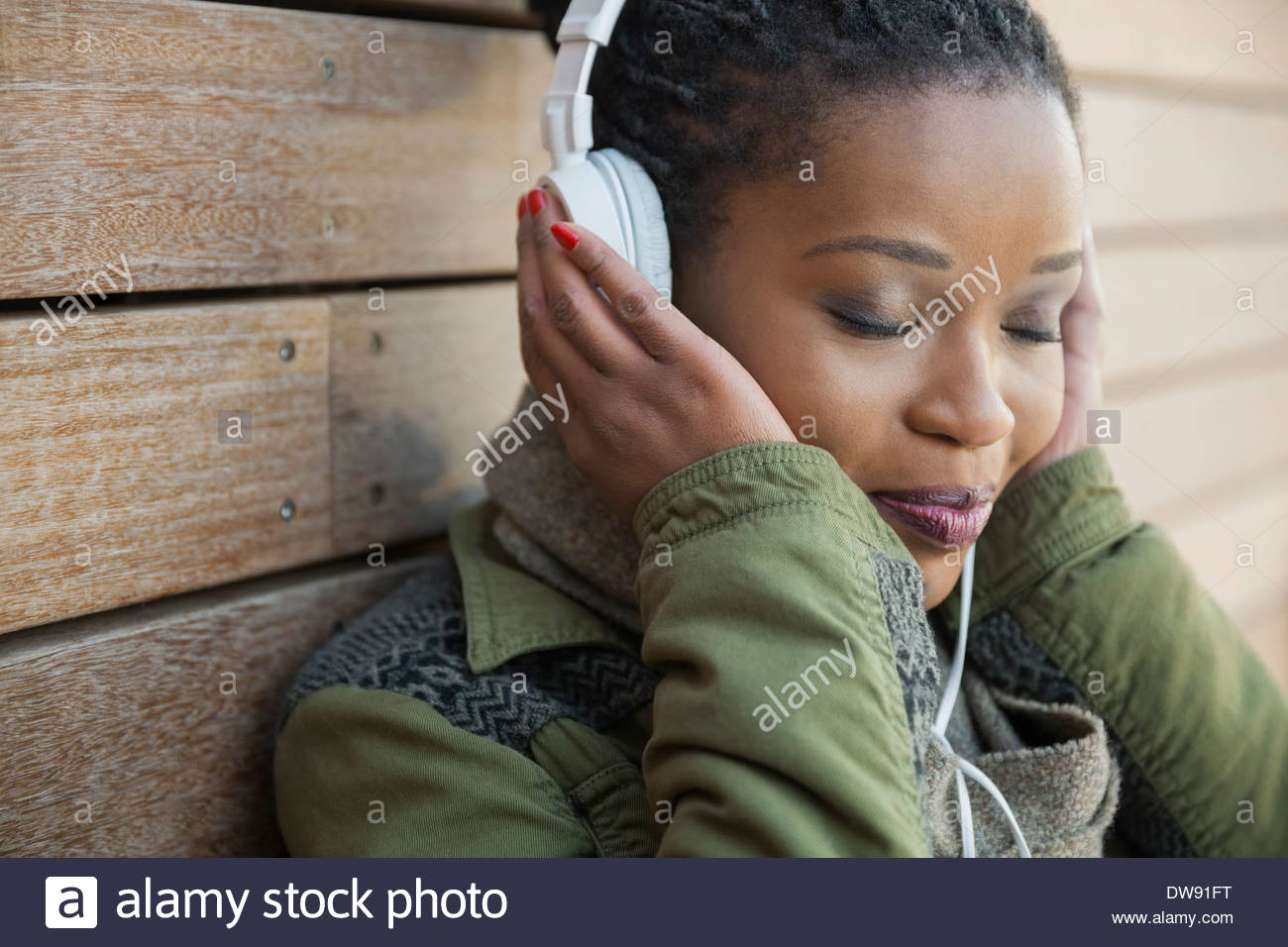 Relaxed woman listening to music outdoors Stock Photo