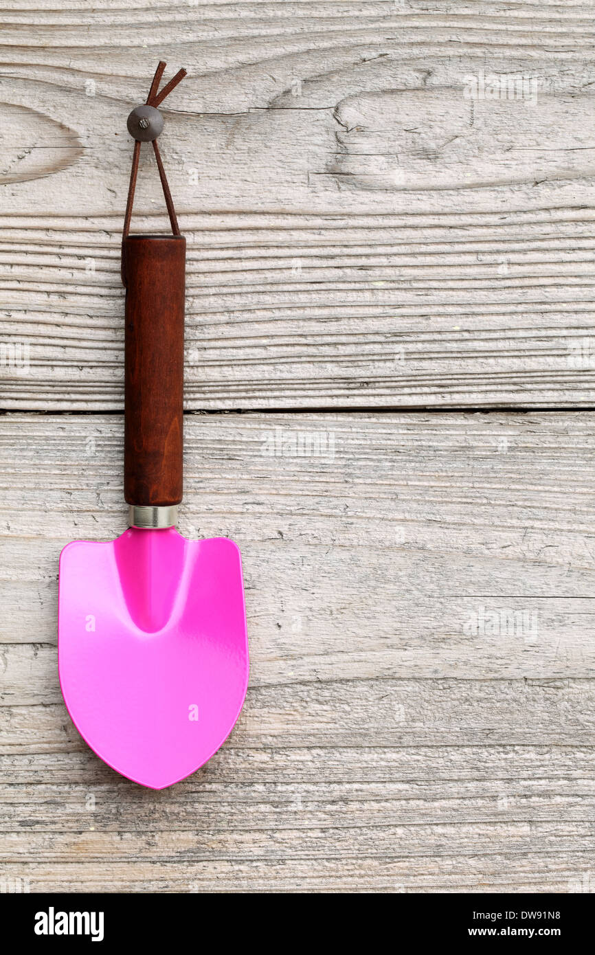 garden shovel hang on grunge wooden wall Stock Photo