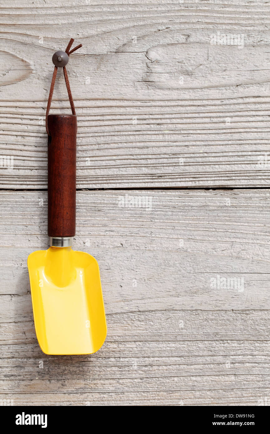 garden shovel hang on grunge wooden wall Stock Photo
