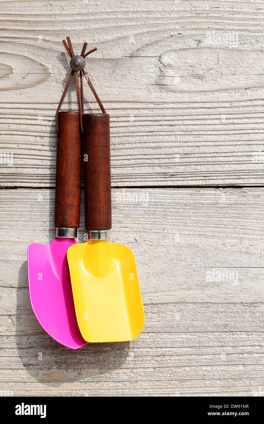 garden tools hang on grunge wooden wall Stock Photo