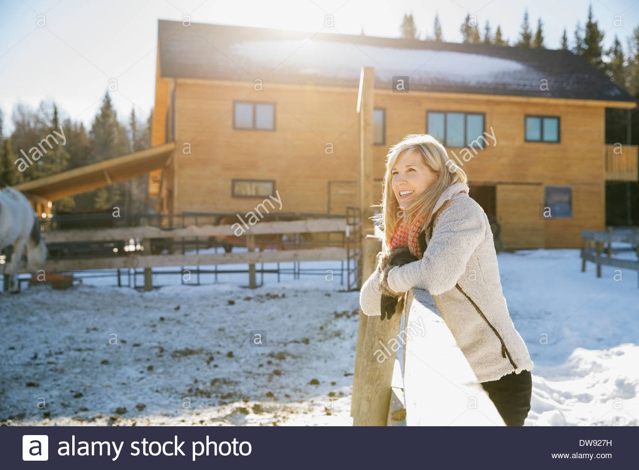 Smiling woman looking out on horse ranch Stock Photo