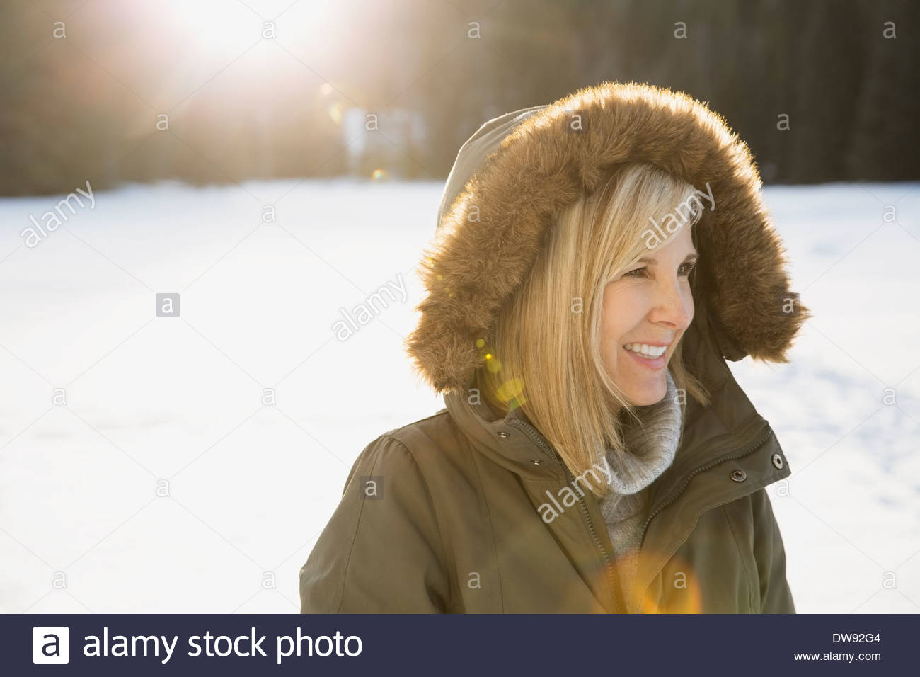 Woman in fur hooded jacket smiling outdoors Stock Photo