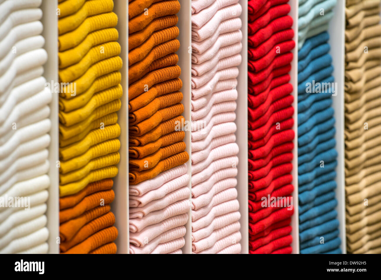 Neat stacks of folded clothing on the shop shelves Stock Photo