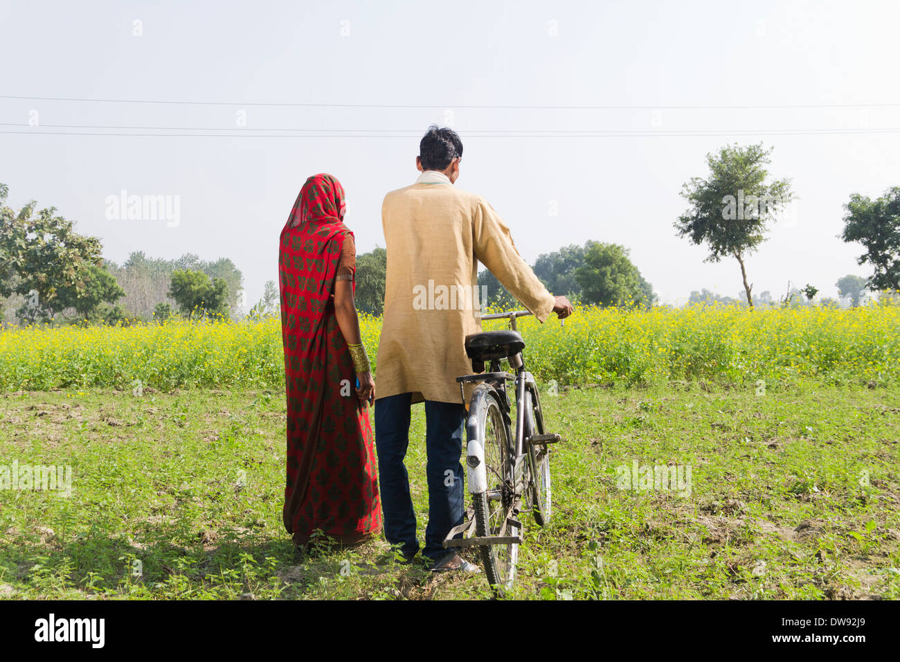 Indian farmer standing with wife in farm Stock Photo