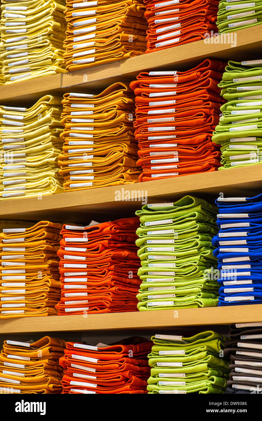 Neat stacks of folded clothing on the shop shelves Stock Photo