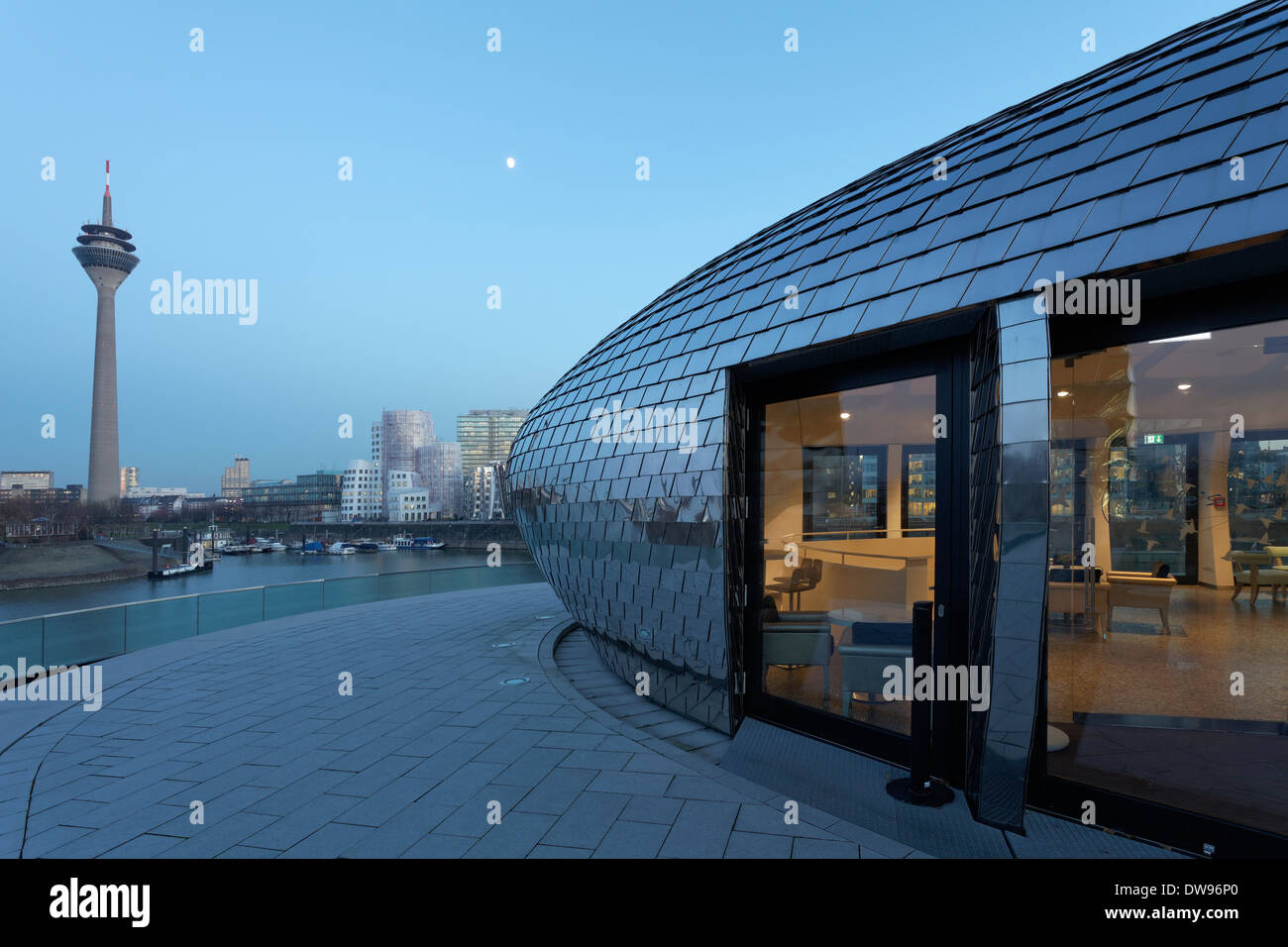 Futuristic pavilion with a mirrored facade, Hyatt Regency hotel bar 'Pebble's' at the blue hour, Media Harbour, Düsseldorf Stock Photo