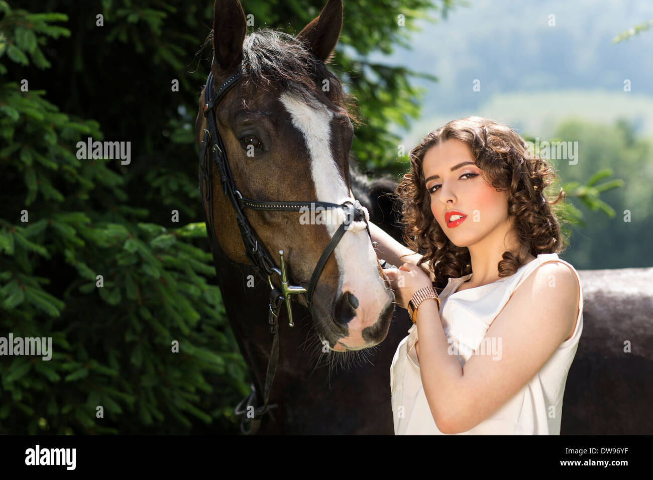 Young woman standing beside a horse Stock Photo