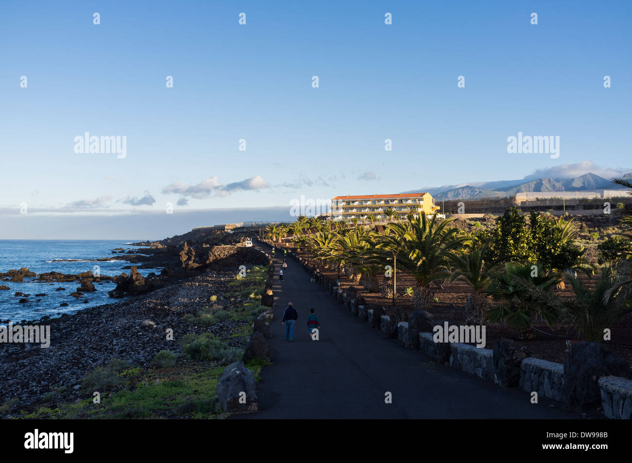 Early morning walkers on the coastal path in Playa San Juan, Tenerife, canary Islands, Spain. Stock Photo