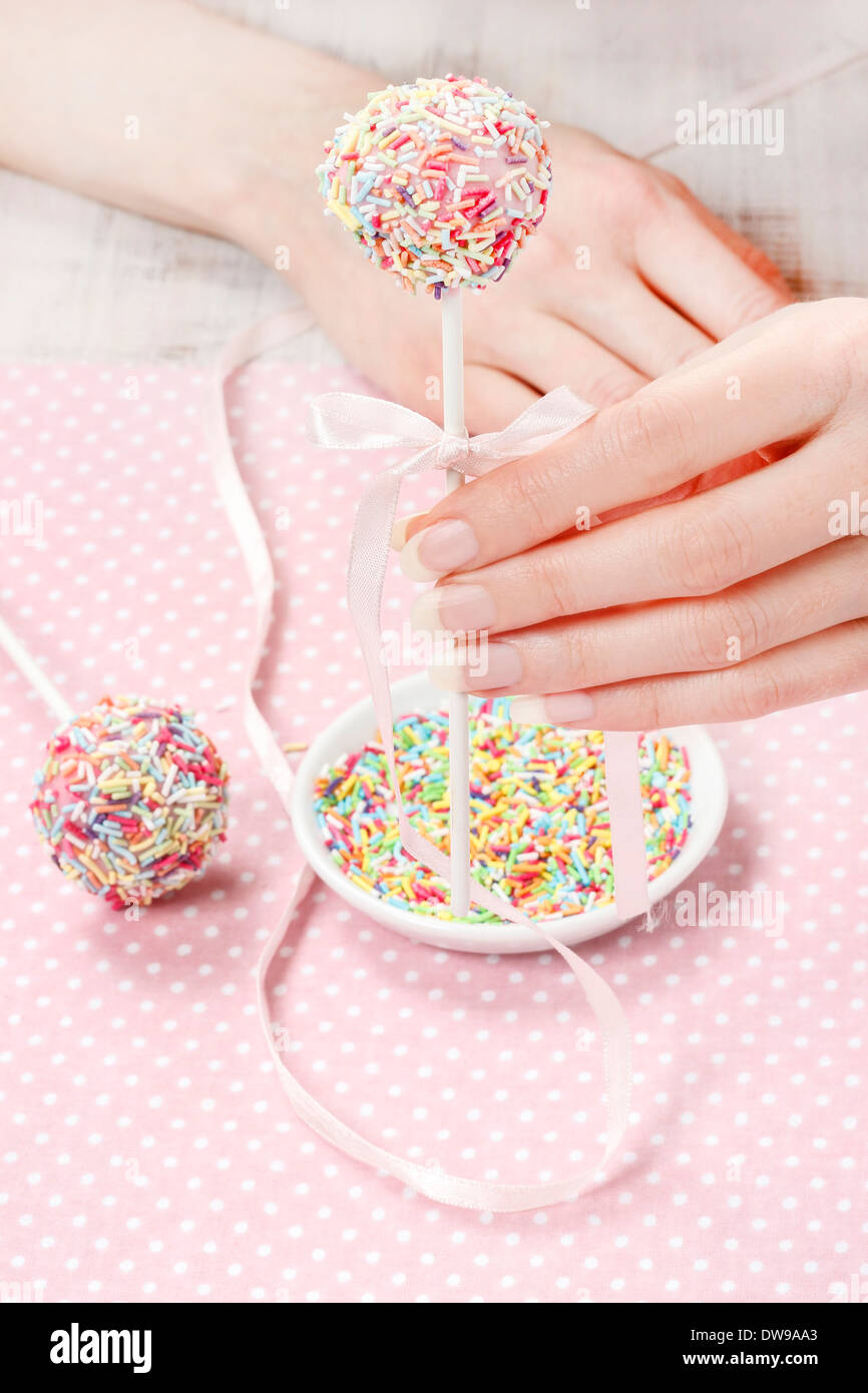 Decorating cake pops with colorful sprinklesDecorating cake pops with