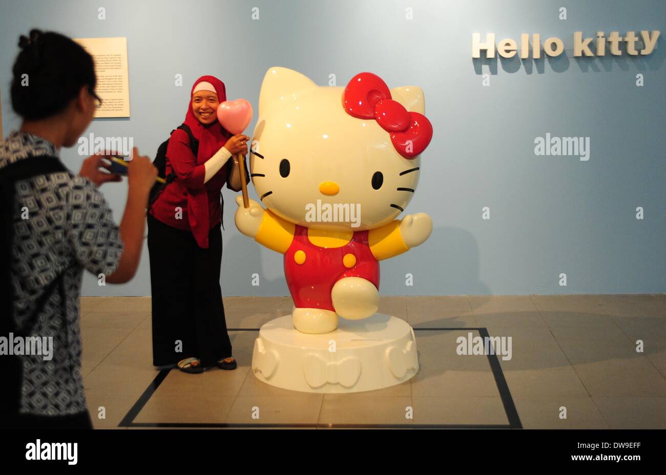 Jakarta, Indonesia. 4th Mar, 2014. A woman poses for photos beside a cartoon character during the Japanese Pop Culture Characters Exhibition in Jakarta, Indonesia, March 4, 2014. The exhibition is held from March 4 to March 23. © Zulkarnain/Xinhua/Alamy Live News Stock Photo