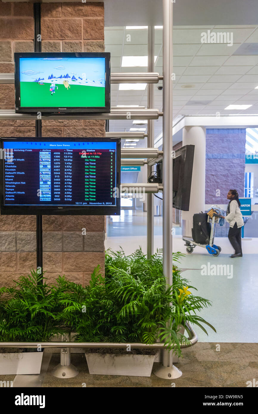 Animated cartoon plays on screen a above arrival information at Pensacola International Airport in Pensacola, Florida Stock Photo