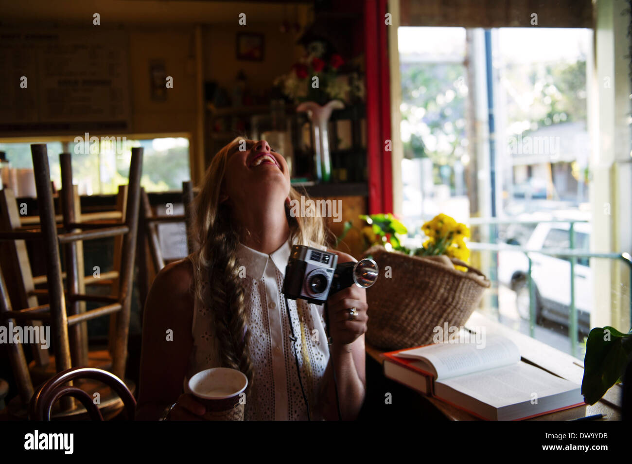 Young woman with camera in cafe Stock Photo