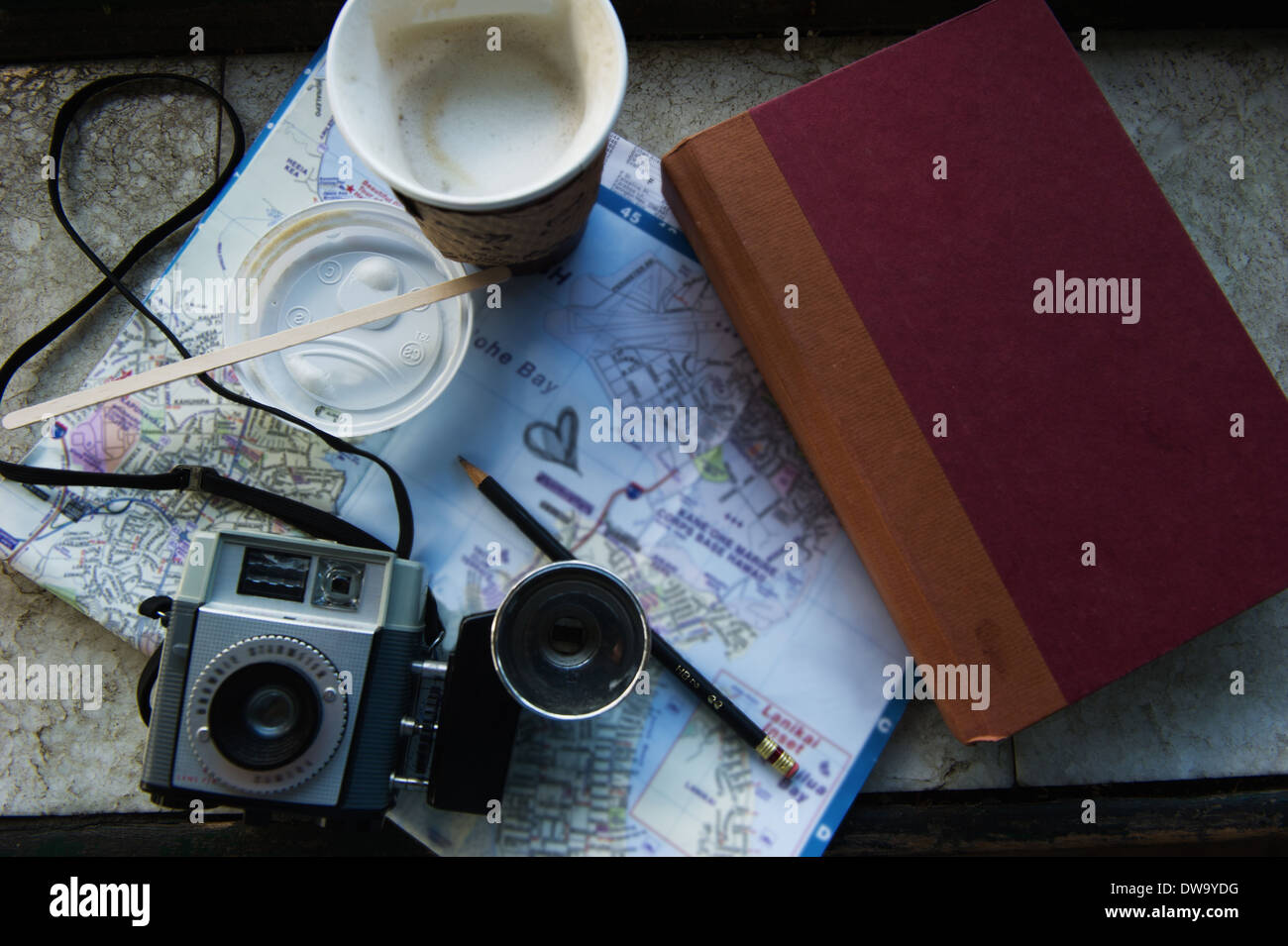 Camera, coffee and book on map Stock Photo