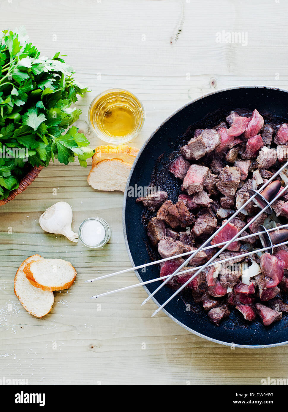Skewers and meat cooking in pan Stock Photo