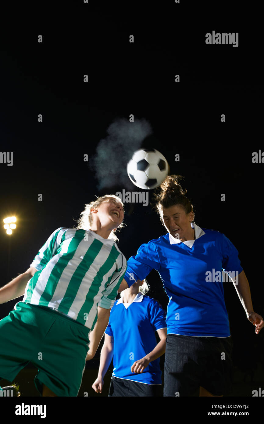 Female soccer players hitting ball with head Stock Photo