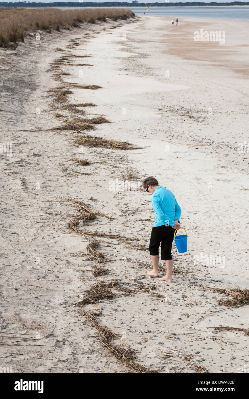 Woman looking for shells on the beach in Fort Clinch State Park on Amelia Island, Florida Stock Photo