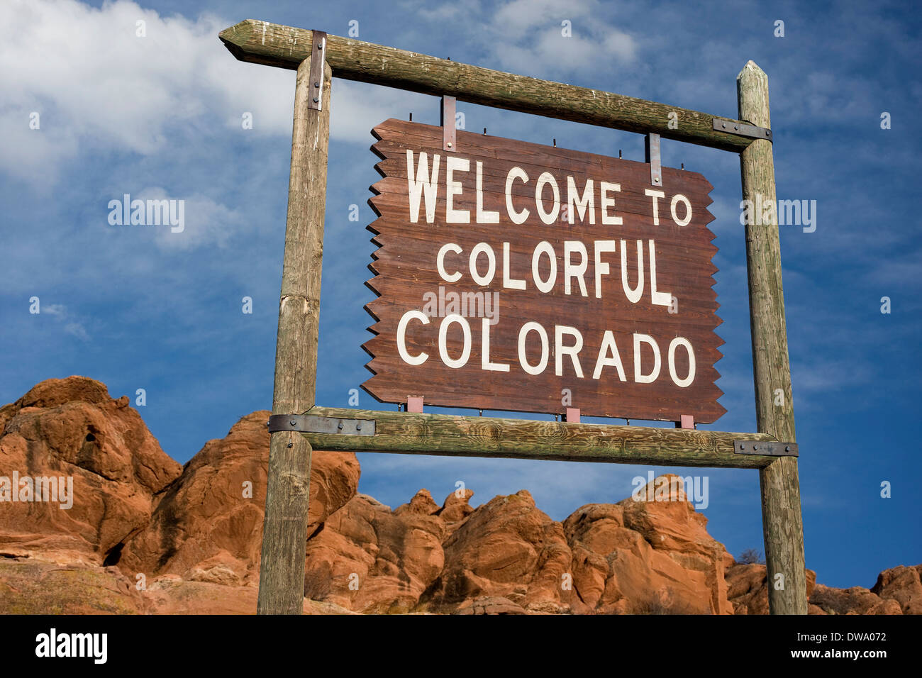 welcome to colorful Colorado roadside wooden sign with red sandstone cliff in background Stock Photo