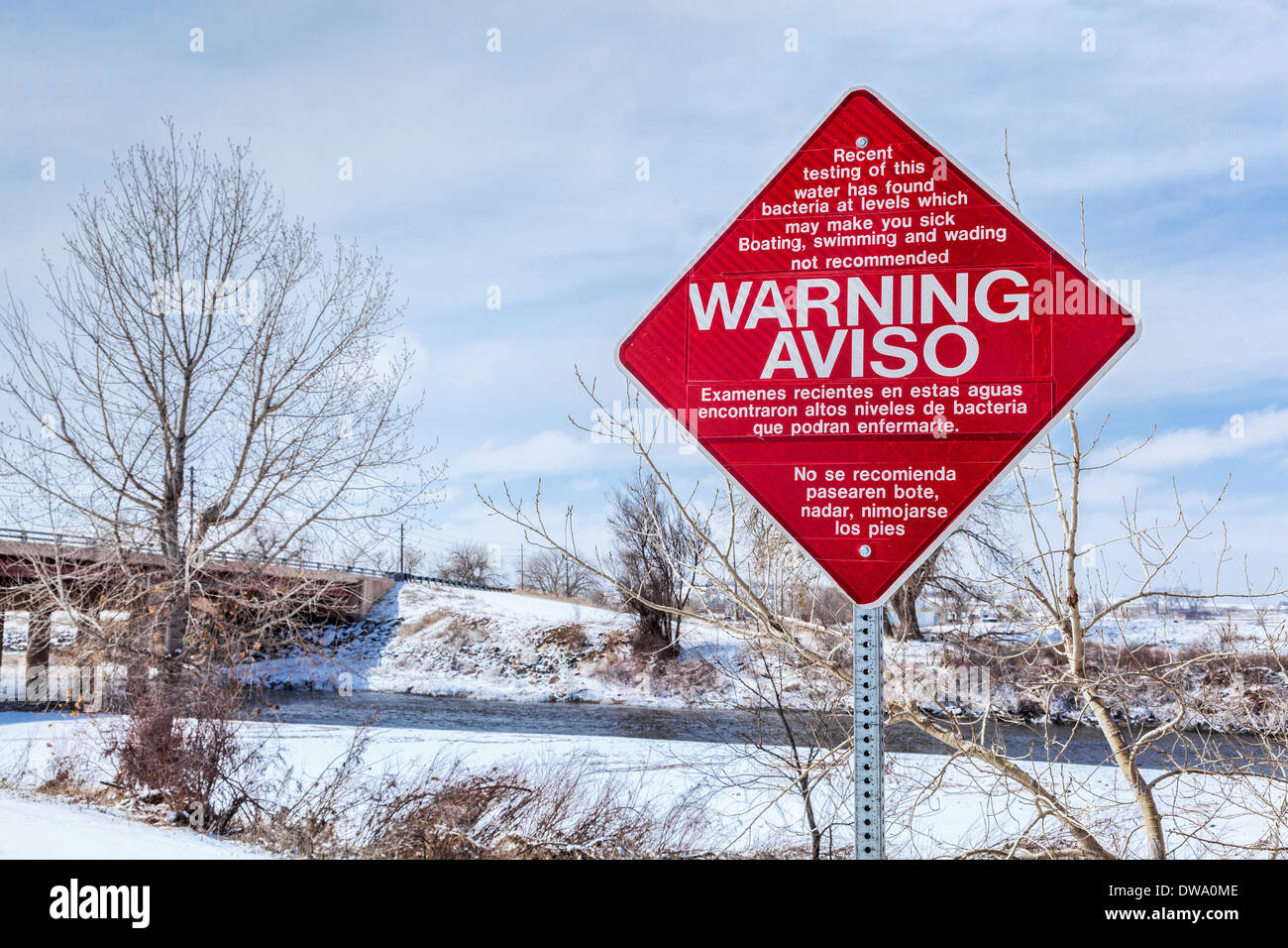 water pollution warning sign in English and Spanish - South Platte River at Brighton, Colorado Stock Photo